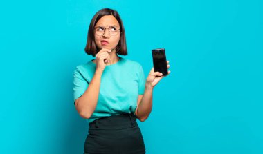 Genç İspanyol kadın düşünüyor, kuşkulu ve şaşkın hissediyor, farklı seçeneklerle, hangi kararı vereceğini merak ediyor.