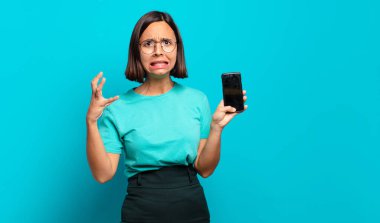 Genç İspanyol kadın ellerini havaya kaldırıp bağırıyor. Öfkeli, sinirli, stresli ve üzgün.