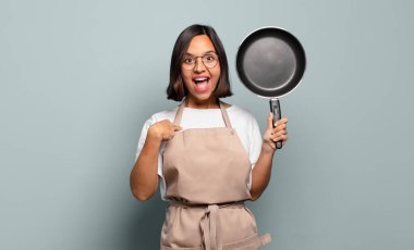 Genç İspanyol kadın mutlu, şaşkın ve gururlu hissediyor. Heyecanlı ve şaşkın bir bakışla kendini işaret ediyor.