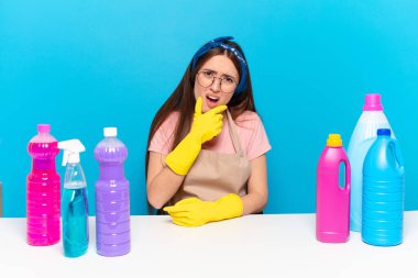 Ağzı ve gözleri açık, eli çenesinde, hoş olmayan bir şekilde şokta olan genç, güzel bir ev bekçisi.