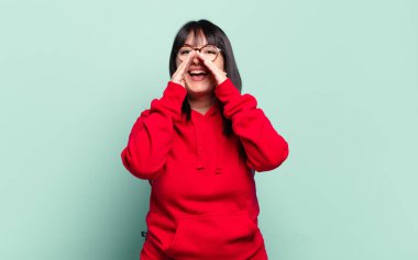 Ayrıca boyunda güzel bir kadın mutlu, heyecanlı ve pozitif hissediyor. Elleri ağızda, bağırıyor.