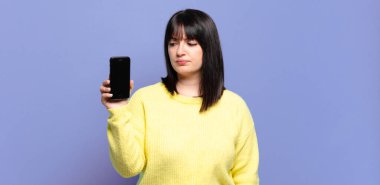 Artı boyut olarak güzel bir kadın üzgün, üzgün ya da kızgın ve olumsuz bir tavır takınıyor, anlaşmazlıkla kaşlarını çatıyor.