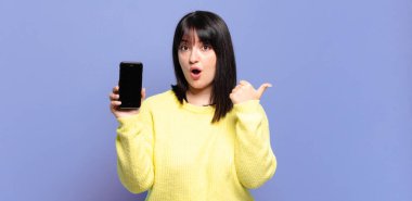 Ayrıca cüsseli güzel bir kadın inançsızlıktan şaşkın şaşkın bakıyor, yan taraftaki objeyi işaret ediyor ve diyor ki: