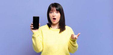 Artı boyut olarak güzel bir kadın ağzı açık ve şaşkın, şok olmuş ve hayretler içinde inanılmaz bir sürprizle