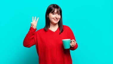 Artı güzel bir kadın gülümsüyor ve arkadaş canlısı görünüyor, üç ya da üç numarayı gösteriyor, eli önde, geriye doğru sayıyor.