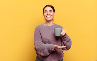 Genç, güzel bir kadın neşeyle gülümsüyor, mutlu hissediyor ve fotokopi alanında bir konsept gösteriyor.