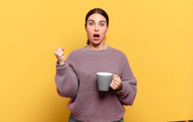 Genç ve güzel bir kadın öfkeli bir ifadeyle ya da yumruklarıyla başarıyı kutlarken agresif bir şekilde bağırıyor.