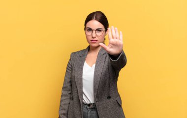 Genç ve güzel bir kadın ciddi, sert, hoşnutsuz ve kızgın görünüyor.