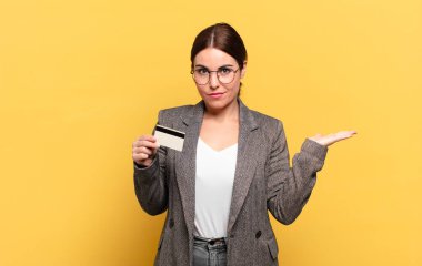 Genç, güzel bir kadın şaşkın ve kafası karışık, şüpheci, farklı seçenekleri tartıyor ya da komik bir ifadeyle seçiyor.