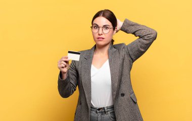 Genç, güzel bir kadın kendini stresli, endişeli, endişeli ya da korkmuş hissediyor. Elleri başının üstünde, hatayla panikliyor.