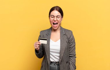 Genç ve güzel bir kadın agresif bir şekilde bağırıyor, kızgın, sinirli, öfkeli ya da sinirli görünüyor.