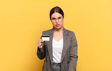 Genç, güzel bir kadın şaşkın ve şaşkın hissediyor, aptal, sersemlemiş bir ifadeyle beklenmedik bir şeye bakıyor.