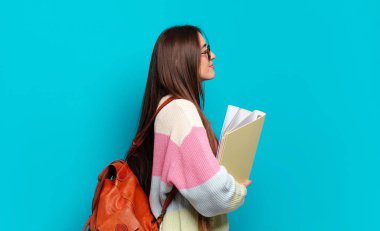 Profil görünümünde genç ve güzel bir kadın ilerideki boşluğu kopyalamaya çalışıyor, düşünüyor, hayal ediyor ya da hayal kuruyor.