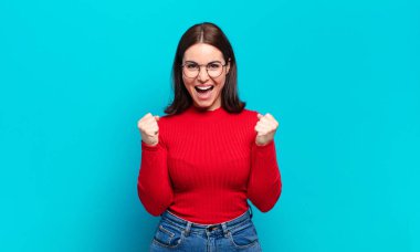 Genç ve hoş bir kadın şok olmuş, heyecanlı ve mutlu hissediyor, gülüyor ve başarıyı kutluyor,!