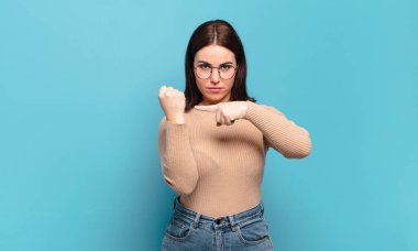 Genç, sıradan, sabırsız ve kızgın görünen, saati gösteren, dakiklik isteyen, tam zamanında olmak isteyen bir kadın.