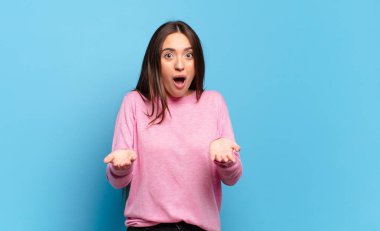 Genç, hoş, rahat bir kadın ağzı açık ve şaşkın, şok olmuş ve hayrete düşmüş inanılmaz bir sürprizle