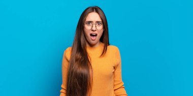 Genç, hoş, sıradan bir kadın korkmuş ve şok olmuş hissediyor, ağzı açık ve şaşkınlık içinde.