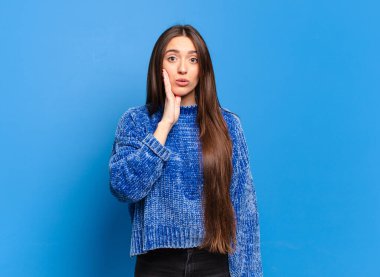 Genç, hoş, sıradan bir kadın şok olmuş ve ağzı açık bir şekilde yüz yüze inanmamak için sarmaş dolaş.