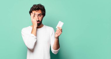 Hap tabletli çılgın sakallı genç adam.