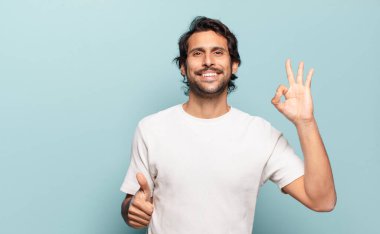 Genç, yakışıklı Hintli adam kendini mutlu, şaşkın, tatmin olmuş ve şaşırmış hissediyor.