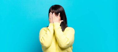 Artı boyut olarak güzel bir kadın korkmuş ya da utanmış hissediyor, gözleri yarı kapalı ya da elleri kapalı gözetliyor ya da dikizliyor.