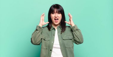 Artı boyut olarak güzel bir kadın elleri havada bağırıyor, öfkeli, sinirli, stresli ve üzgün hissediyor.