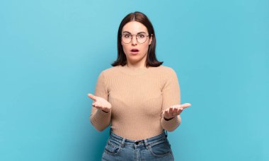 Genç, hoş, rahat bir kadın ağzı açık ve şaşkın, şok olmuş ve hayrete düşmüş inanılmaz bir sürprizle