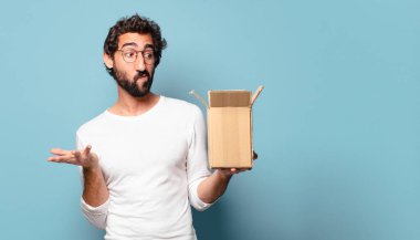 Genç çılgın sakallı adam karton bir pakete karşılık veriyor.
