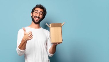 Genç çılgın sakallı adam karton bir pakete karşılık veriyor.