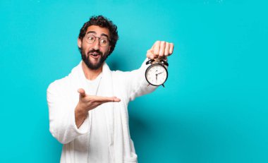 Bornoz ve çalar saat takan genç çılgın sakallı adam.