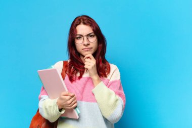 Mavi arka planda güzel bir öğrenci kadın.