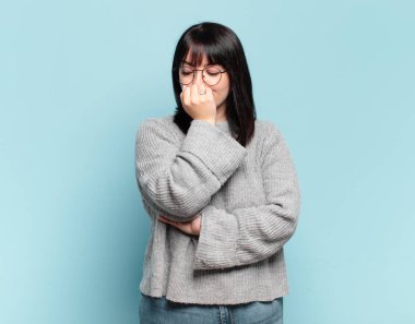 Ayrıca boyunda güzel bir kadın ciddi, düşünceli ve endişeli, eli çenesine değmiş şekilde yan yan bakıyor.