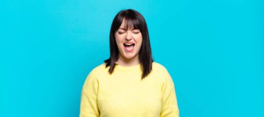 Artı boyut olarak güzel bir kadın agresif bir şekilde bağırıyor, sinirli, sinirli ya da sinirli görünüyor, hayır diye bağırıyor