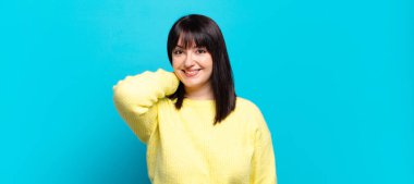 Artı, güzel bir kadın neşeli ve kendinden emin bir şekilde gülüyor, mutlu, dostane bir gülümsemeyle.