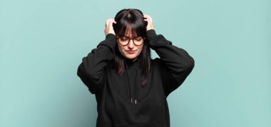 Artı boyut olarak güzel bir kadın stresli ve hayal kırıklığına uğramış hissediyor, el ele tutuşuyor, yorgun, mutsuz ve migren ağrısı çekiyor.