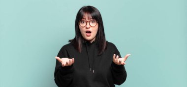 Artı boyut olarak güzel bir kadın aşırı derecede şaşırmış, şaşırmış, endişeli ve paniklemiş, stresli ve dehşete kapılmış görünüyor.