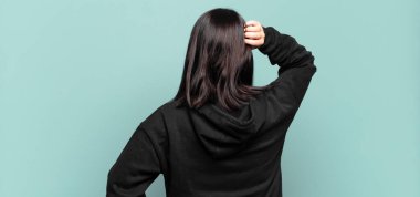 Artı boyut olarak güzel bir kadın bilgisiz ve kafası karışık, bir çözüm düşünüyor, eli kalçasında, diğeri de kafasında, dikiz aynasından.