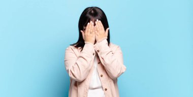 Artı boyut olarak güzel bir kadın üzgün, hayal kırıklığına uğramış, gergin ve depresif, iki eliyle yüzünü kaplayan, ağlayan