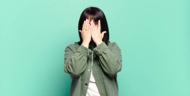 Artı boyut olarak güzel bir kadın korkmuş ya da utanmış hissediyor, gözleri yarı kapalı ya da elleri kapalı gözetliyor ya da dikizliyor.