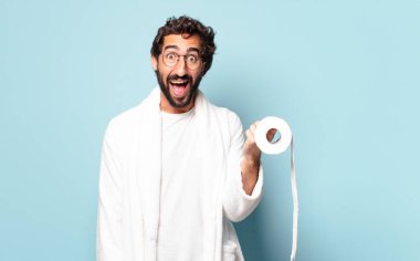 Bornoz ve tuvalet kâğıdı giyen çılgın sakallı genç adam.