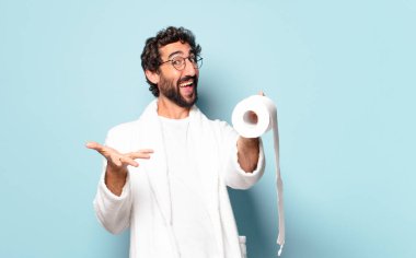 Bornoz ve tuvalet kâğıdı giyen çılgın sakallı genç adam.