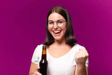 Genç ve güzel bir kadın bira içiyor.