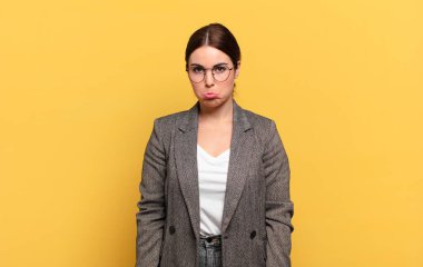 Genç ve güzel bir kadın üzgün ve mızmızlanıyor, mutsuz bir bakışla, negatif ve hayal kırıklığına uğramış bir tavırla ağlıyor.