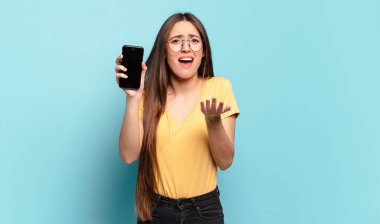 Genç ve güzel bir kadın umutsuz ve hayal kırıklığına uğramış görünüyor, stresli, mutsuz ve sinirli, bağırıyor ve çığlık atıyor.