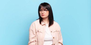 Artı boyut olarak güzel bir kadın üzgün, üzgün ya da kızgın ve olumsuz bir tavır takınıyor, anlaşmazlıkla kaşlarını çatıyor.