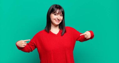 Artı boyut olarak güzel bir kadın gururlu, kibirli, mutlu, şaşırmış ve tatmin olmuş görünüyor, kendini gösteriyor, kazanan gibi hissediyor.