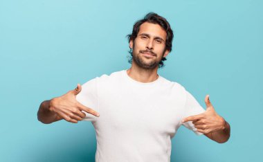 Genç, yakışıklı Hintli bir adam gururlu, kibirli, mutlu, şaşırmış ve tatmin olmuş görünüyor.