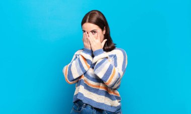 Genç, hoş, sıradan bir kadın korkmuş ya da utanmış hissediyor. Gözleri yarı kapalı ya da ellerle dikizliyor ya da gözetliyor.