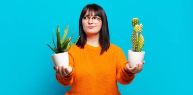 Ayrıca elinde kaktüs tutan güzel bir kadın. aloe vera kavramı