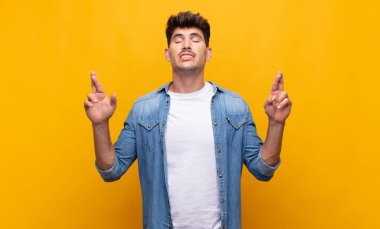 Genç yakışıklı adam gergin ve umutlu, şans diliyor ve dua ediyor.